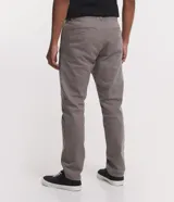 Pantalón de vestir marrón, de corte skinny, con bolsillos laterales y traseros. Se ajusta a la cintura con cinturón de cuero marrón.