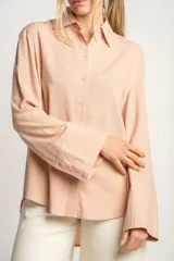 Camisa color salmón de corte oversize, confeccionada en lino y viscosa, con cuello clásico, cierre frontal con botones y mangas largas con puños anchos.