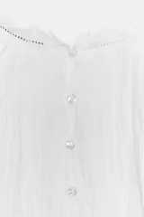 Camisa blanca de cuello redondo con detalle de nido de abeja y entredoses. Manga larga con bordados a tono y cierre trasero con botones.