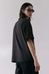 Remera negra de algodón con estampado del logo de Metallica y la imagen de la banda Damage Inc. 1986. Corte oversized con cuello redondo ribeteado, hombros caídos y bajo recto.