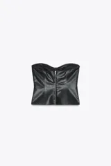 Top tipo corsé negro de cuero sintético, con escote corazón y hombros descubiertos. Detalle de costuras marcadas y cierre trasero con cremallera.