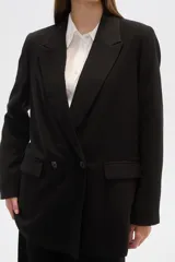 Blazer negro de corte holgado, con cuello solapa, cierre con doble botón y bolsillos laterales con solapa.