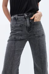 Pantalón de jean de tiro alto, corte recto y largo hasta el tobillo. Presenta bolsillos delanteros con solapa y alforza central.