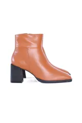 Botines de cuero color caramelo, con caña media, cierre lateral y puntera cuadrada. El tacón es bloque de color negro de aproximadamente 7 cm.