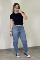 Pantalón jean mom celeste de tiro alto, corte holgado y tobillos ajustados.