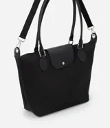 Cartera grande negra de poliéster con cierre de cremallera y solapa. Tiene doble asa, una fija para el hombro y otra transversal desmontable.