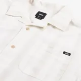 Camisa de manga corta color blanco con rayas verticales, cuello cubano, cierre con botones y bolsillo en el pecho.