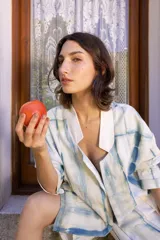 Conjunto de chaqueta y short color blanco con estampado de líneas azules. La chaqueta es de corte recto con cuello camisero y mangas cortas. El short es de tiro alto con bolsillos laterales.