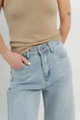 Pantalón de jean celeste claro, corte palazzo, tiro alto, bolsillos delanteros y traseros, y detalle metálico con el logo Peach en el bolsillo trasero.