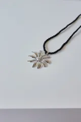 Collar con dije de acero quirúrgico hipoalergénico en forma de margarita plateada y tiento sailor color borgoña.