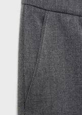 Pantalón gris de corte recto, tiro medio y diseño crop. Con cierre de cremallera y gancho, trabillas y bolsillos laterales.