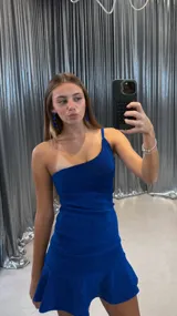 Vestido corto azul brillante con un solo hombro y falda con volados.