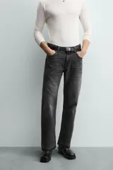 Pantalón de jean celeste de corte flare, con tiro medio, cinco bolsillos, cierre frontal con cremallera y botón, y bajo con acabado irregular.