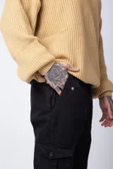 Pantalón cargo color beige con bolsillos laterales con solapa y botón. Corte ajustado.