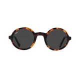 Lentes de sol redondos con armazón de carey (caramelo/marrón) y cristales oscuros. La marca "Indie" está impresa en la esquina superior izquierda del lente izquierdo.