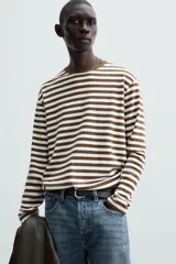 Remera de manga larga a rayas horizontales marrones y blancas, de corte recto y cuello redondo.