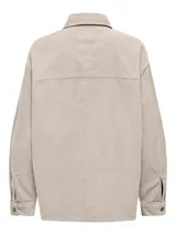 Camisa color crema de pana con corte oversize, cuello clásico, hombros caídos, bolsillos frontales con solapa y cierre de botones.