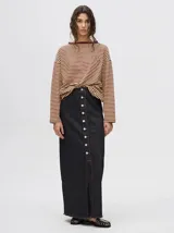 Falda larga de jean color negro con hilado blanco, corte recto y abertura frontal con botones.