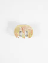 Broche de pelo tipo pinza de acrílico con diseño abstracto y efecto marmolado en tonos amarillo pálido, rosado y blanco.