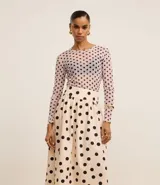 Pollera midi evasé de tricolina color beige con lunares negros, cintura ancha con elástico en la espalda y algodón certificado BCI.