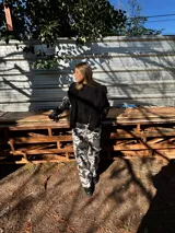 Pantalón largo de tiro bajo con estampado de manchas de vaca en tonos blanco y gris.