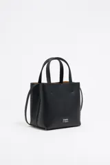 Bolso de mano negro Bimba y Lola modelo Chihuahua S, fabricado en piel regenerada con piezas de metal. Cuenta con asa regulable de piel, cierre con cinta de piel, logo metálico BIMBA Y LOLA, acabados metálicos, bolsillo interior con cierre de cremallera e interior con logo grabado.