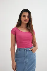 Remera fucsia de algodón con elastano, corte ajustado, escote off-shoulder y mangas cortas.