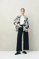 Pantalón de jean azul oscuro, de corte ancho y tiro alto, con bolsillos delanteros cuadrados y amplios.