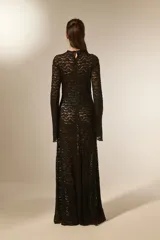 Vestido largo negro de manga larga y cuello alto, confeccionado en poliéster con corte evasé.