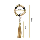 Llavero con pulsera de cuentas de silicona en color blanco, negro y animal print. Incluye un dije de flecos de cuero sintético color beige y un gancho metálico.