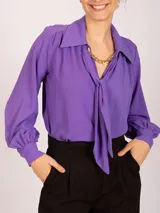 Blusa color violeta con lazo en el cuello, de manga larga y puños elásticos.