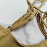 Traje de baño enterizo con diseño de bloques de color: celeste en la parte superior, blanco en el centro y marrón en la parte inferior. Tiene tirantes finos color marrón.