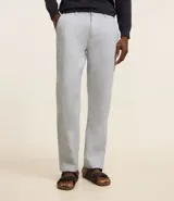 Pantalón de lino blanco de corte recto, con trabillas en la cintura, cierre tradicional y bolsillos laterales.