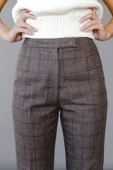 Pantalón acampanado con estampado a cuadros en tonos marrón, beige y rojo.