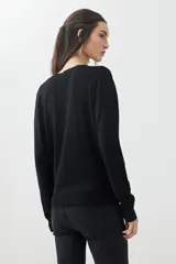 Sweater verde de tejido de punto, con escote en V y mangas largas.