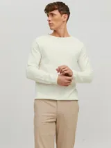Sweater de punto color crudo, de manga larga y cuello redondo.
