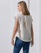Camisa color crema con bordado de hojas color marrón, cuello con solapa, manga corta y cierre frontal con botones.
