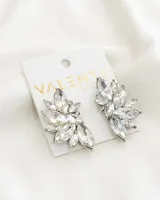 Aros plateados con forma de hojas y cristales blancos.