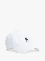 Gorra de béisbol blanca de algodón con diseño de seis paneles, ojales de ventilación, botón en la parte superior y hebilla de ajuste metálica en la parte trasera. Presenta un monograma TH bordado en negro en la parte delantera.