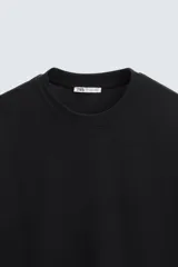 Camiseta blanca de algodón interlock con elasticidad, corte recto, cuello redondo y mangas cortas.