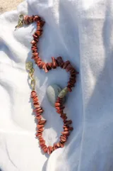 Collar regulable de bronce macizo con cuentas de piedra natural de cuarzo lima y jaspe rojo, y un dije central de labradorita.