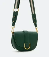 Bolso saddle pequeño color verde esmeralda, con solapa frontal con hebilla metálica dorada y cierre con botón a presión. Incluye correa transversal de grosgrain extraíble y bolsillo interno con cremallera.