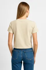 Remera color crema de corte recto y mangas cortas, con estampa de una estrella rosa con diseño floral.