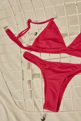 Bikini de triángulo con top fijo que incluye breteles regulables y almohadillas desmontables, y bottom vedetina con frunce elástico en los costados.