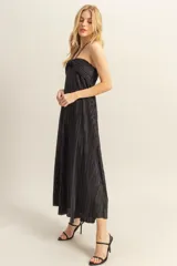 Vestido midi negro con textura plisada, escote halter y corte holgado.