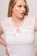 Pijama de modal blanco, compuesto por remera sin mangas con detalle de puntilla en el escote y lazo en el centro, y short con cintura elástica.