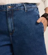 Short de jean azul de tiro alto, con bolsillos delanteros y traseros, trabillas y ruedo desflecado.