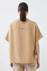 Camisa color pistacho de lyocell con cuello clásico, cierre frontal con botones y mangas cortas.