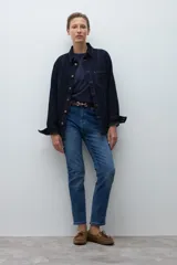 Jean slim de mujer color azul medio, con tiro medio y corte ajustado.