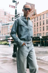 Camisa de denim celeste, de corte recto, con cuello solapa, manga larga, dos bolsillos frontales con solapa y cierre frontal con botones.